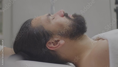 Close-up of a young man's face with a cleansing white mask on his face.