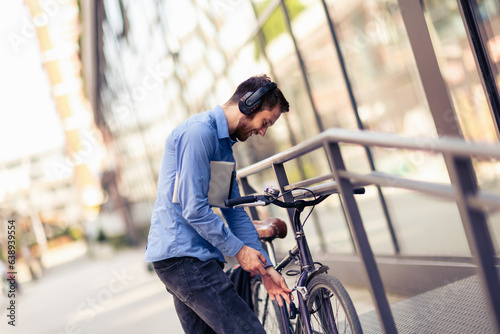 Businessman on bicycle using hands free listening for music. Business, work, and people concepts. photo