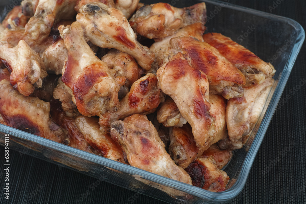 Baked chicken wings in a glass container