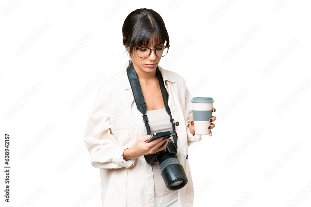Young photographer caucasian woman over isolated chroma key background holding coffee to take away and a mobile Young photographer caucasian woman over isolated chroma key background holding coffee to take away and a mobile