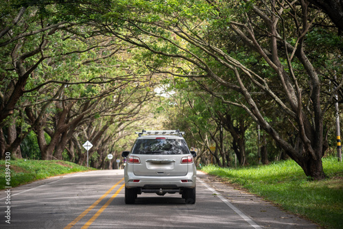 Car on a Colombian highway lined with trees to protect from the sun.