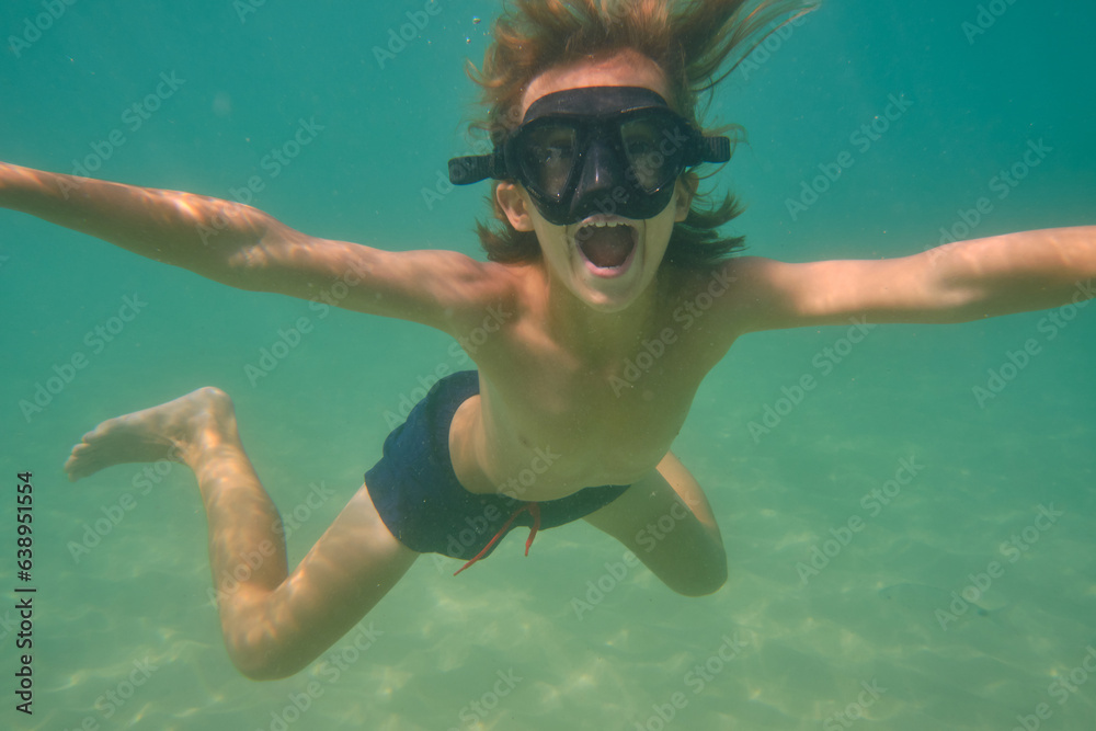 Boy with mouth opened swimming underwater