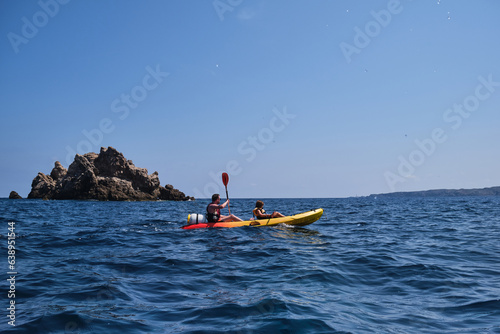 People floating in kayak on sea