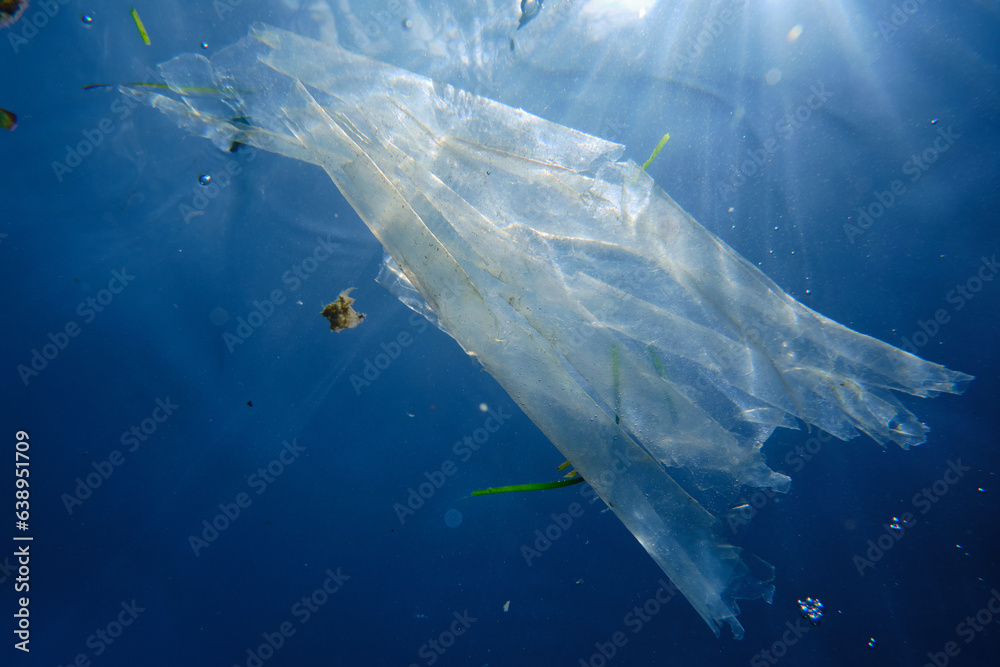 Polluted ocean and plastic bag floating in it