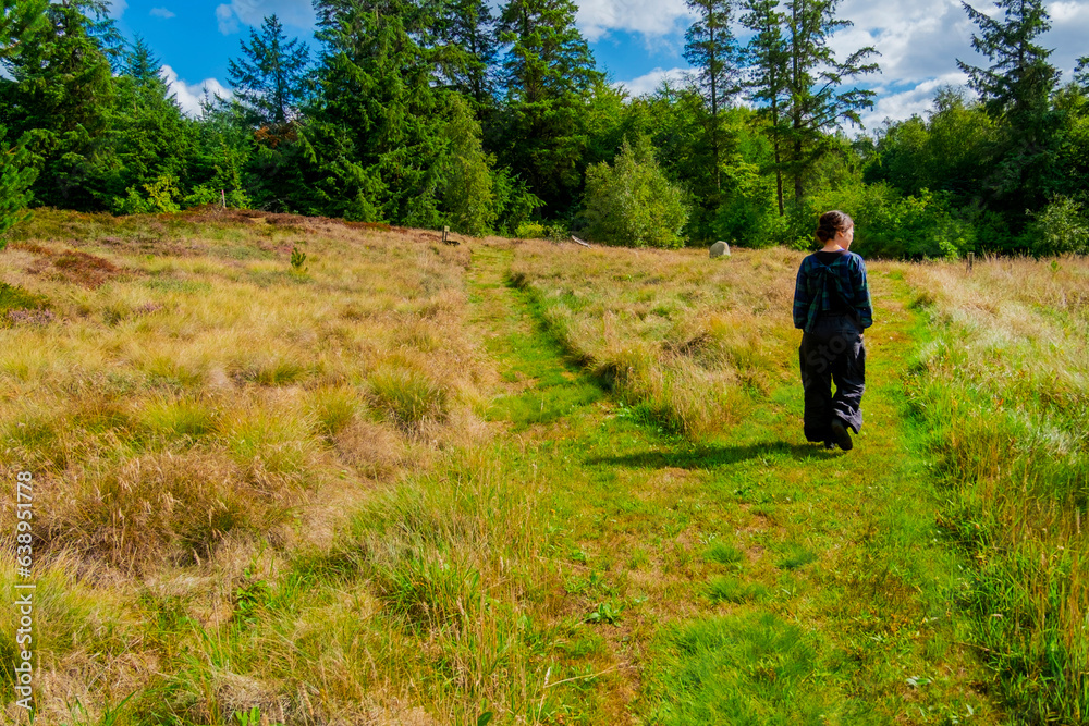 北欧の草原を歩く女性
