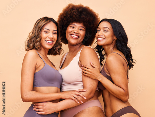 Diversity, natural beauty and portrait of happy women with smile, self love or body positivity in studio. Happy face, group of people on beige background in underwear, skincare inclusion in cosmetics © Anela/peopleimages.com