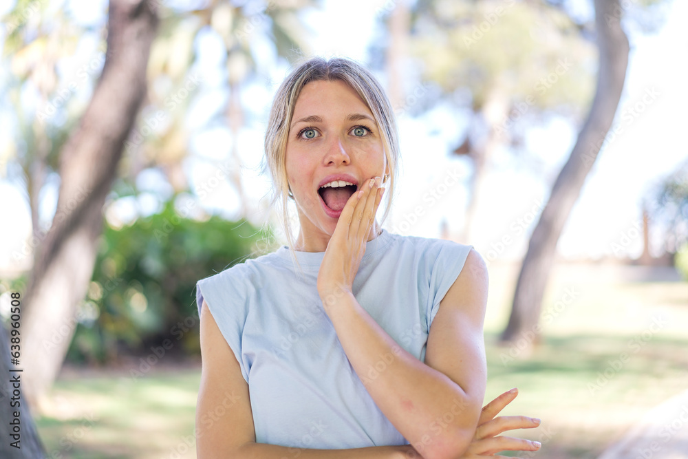 Young blonde woman at outdoors surprised and shocked while looking right
