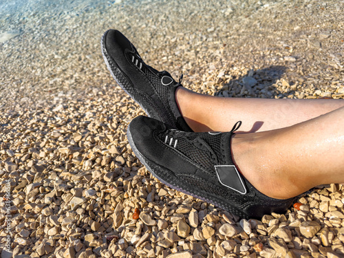 Swimming shoes on the background of a rocky beach.