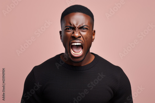 Anger African Man In Black Sweater On Pastel Background. Сoncept Anger Management, African Representation In Media, Impact Of Color On Mood, Power And Representation Of Black Men