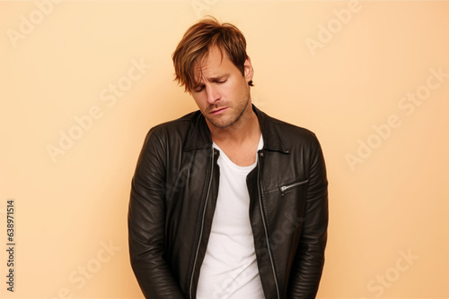 Sadness European Man In Black Jeans On Pastel Background . Сoncept Exploring Sadness In Everyday Life, Psychological Impact Of Color In Photography, Representation Of Europeans In Media photo