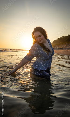 radosna dziewczyna kapiąca się w morzu o wschodzie słońca 