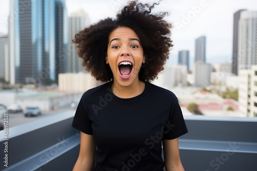 Surprise African Woman In Black Tshirt On City Background. Сoncept African Women In The City, Surprising Representations Of Women, The Meaning Of Tshirts, The Impact Of Urban Imagery