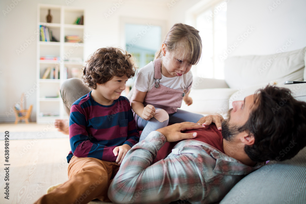 Single father playing with his kids in the living room at home and having fun Single father playing with his kids in the living room at home and having fun