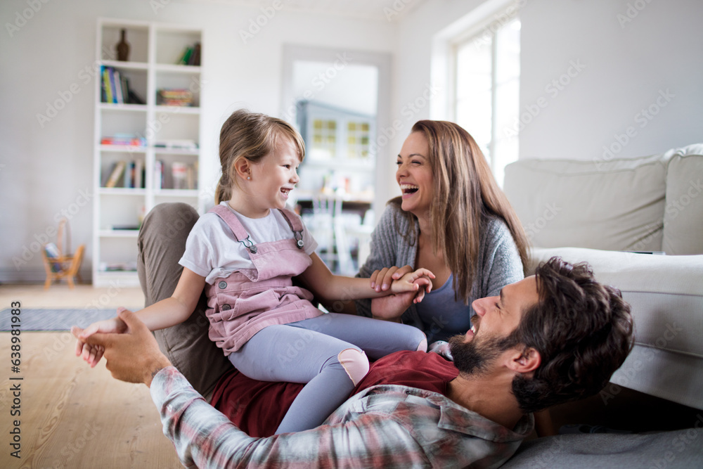 Fototapeta premium Young caucasian family having fun and playing together in the living room