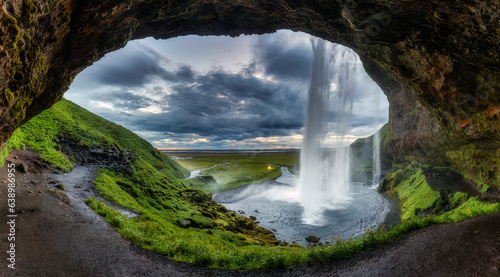 Natural cave with Seljalandsfoss waterfall flowing in summer at Iceland