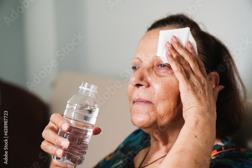 senior woman sweating suffering heat stroke at home