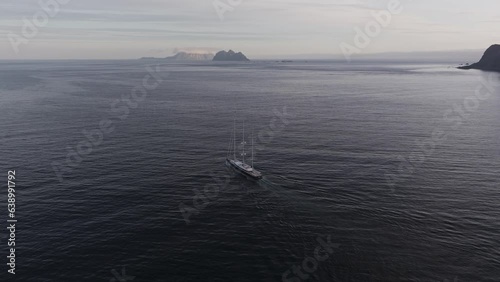 Wallpaper Mural Captured by a drone in 4k, the aerial view showcases a lone boat navigating the ocean amidst snow-covered mountains in Lofoten, Norway. Torontodigital.ca