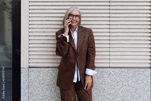 close-up of a successful well-groomed pretty gray-haired woman pensioner walking around the city