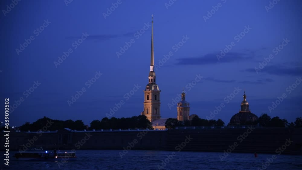 Side view from tour boat of illuminated Russian Orthodox Saints Peter and Paul Cathedral at night in Saint Petersburg, Russia. Religious architecture. Real time handheld video. Water tourism theme. Side view from tour boat of illuminated Russian Orthodox Saints Peter and Paul Cathedral at night in Saint Petersburg, Russia. Religious architecture. Real time handheld video. Water tourism theme.
