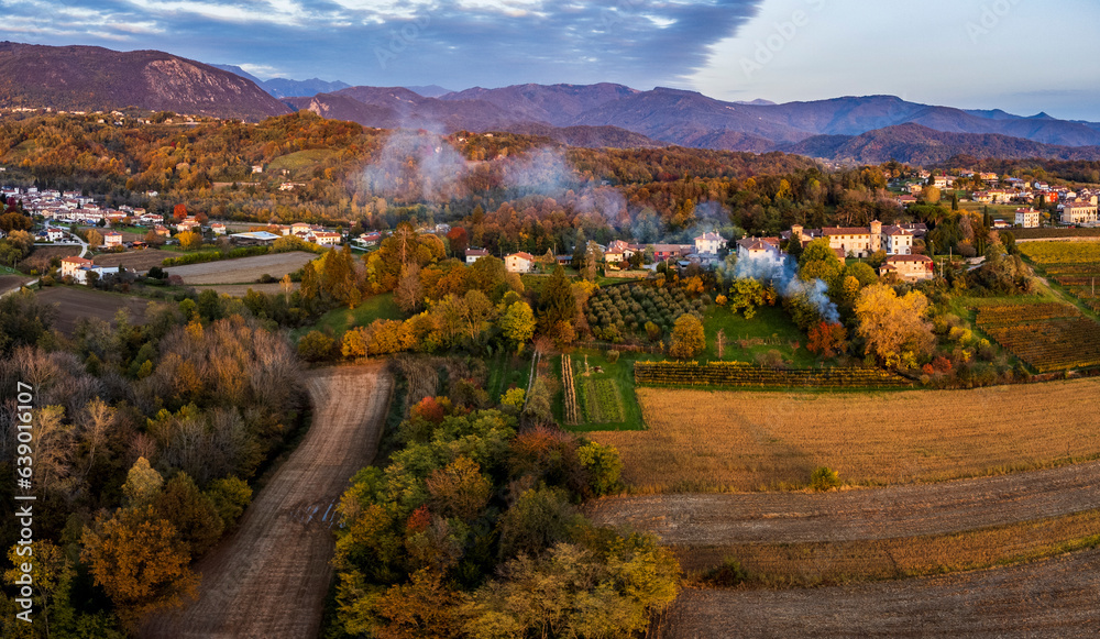 Autumnal magic and emotions on the ancient village. Between vineyards and colorful woods. Friuli. Top view