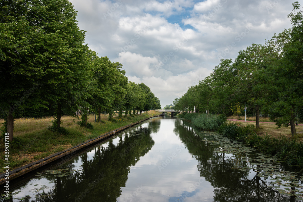 Fototapeta premium Green banks of the Leidsche Rijn , reflecting the surrounding nature, The Netherlands
