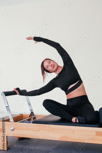 Woman doing Pilates exercise on pilates reformer bed