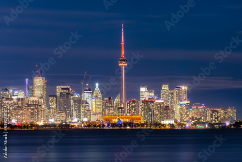 Toronto, Canada - March 7, 2023 : The Glowing Toronto skyline lit up at night over Lake Ontario