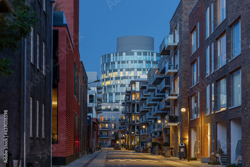 Outdoor night street diminishing perspective view among residential buildings toward famous office building "Portland Towers Corporate Offices" in Copenhagen, Denmark. 