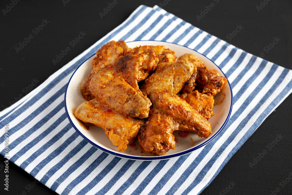 Homemade Rotisserie Chicken Wings with Smoked Paprika and Mayonnaise on a Plate, side view. Homemade Rotisserie Chicken Wings with Smoked Paprika and Mayonnaise on a Plate, side view.