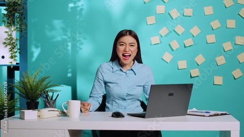 Fotografia Angry emotional businesswoman screaming and slamming fists on table after reaching end of patience at work