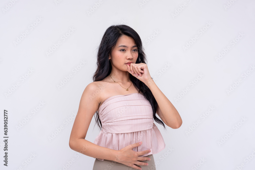 A young asian woman burps in a composed way, gesturing with hand. Isolated on a white background. A young asian woman burps in a composed way, gesturing with hand. Isolated on a white background.