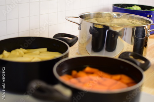 Pots with vegetables on an induction cooktop