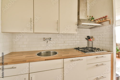 a kitchen with white cupboards and wood counter tops on the counters in this photo is taken from an angle