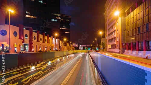 Time-lapse of Lisbon cityscape at dusk - street traffic with long exposure motion blurred car lights trails in Amoreiras, Lisbon, Portugal photo