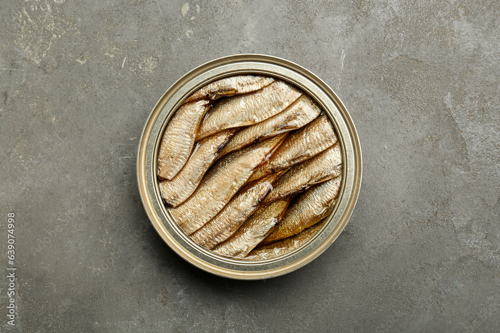 Sprats in tin can on grey textured table, top view Sprats in tin can on grey textured table, top view