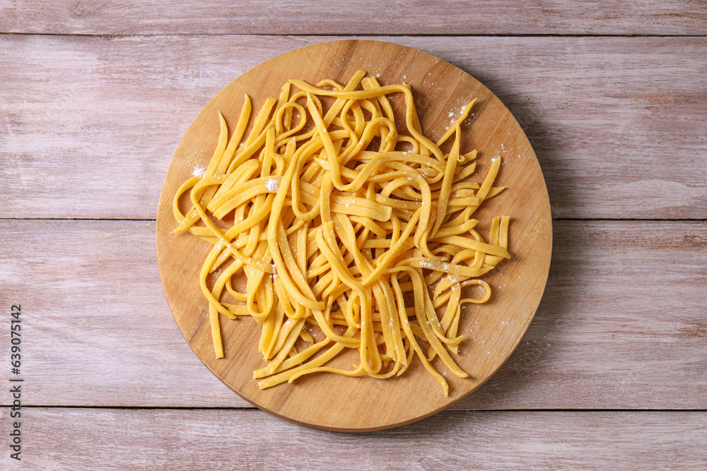 Board with homemade pasta on wooden table, top view Board with homemade pasta on wooden table, top view
