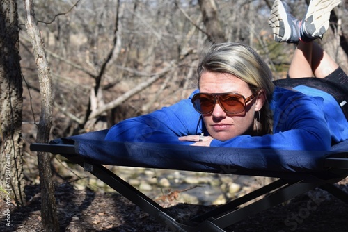 Woman Camping in Woods on a Cot