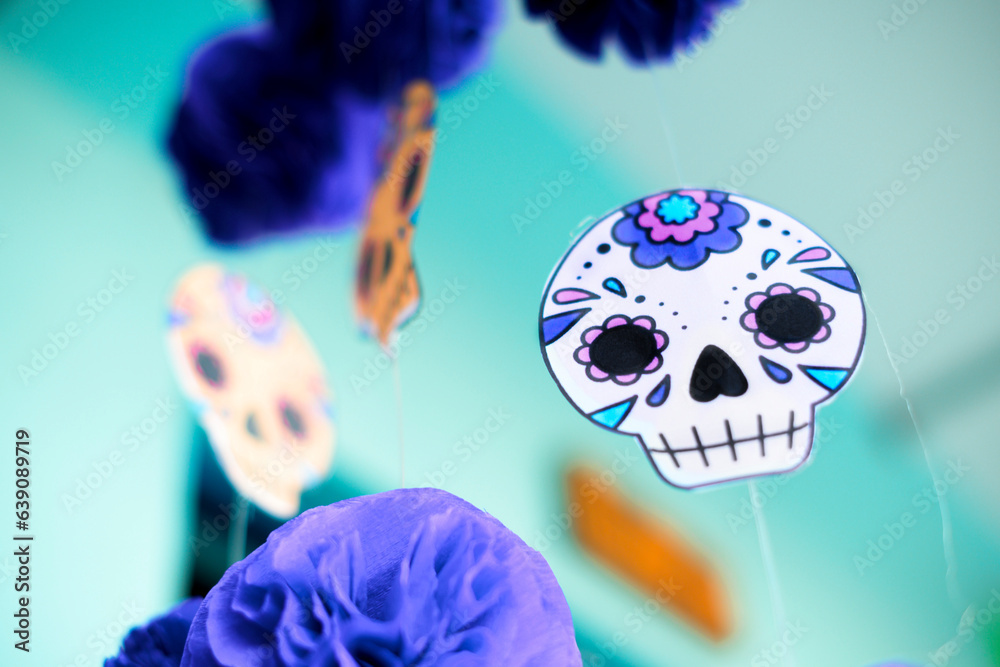 decorative paper in the shape of a catrina hanging next to papel picado ...
