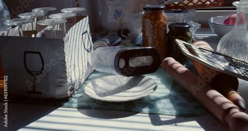 The slow panning of the camera reveals the mess on the kitchen counter in the morning sun. photo
