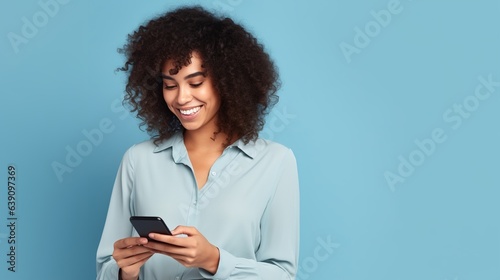 Young adult smiling happy pretty latin woman holding mobile phone looking at smartphone