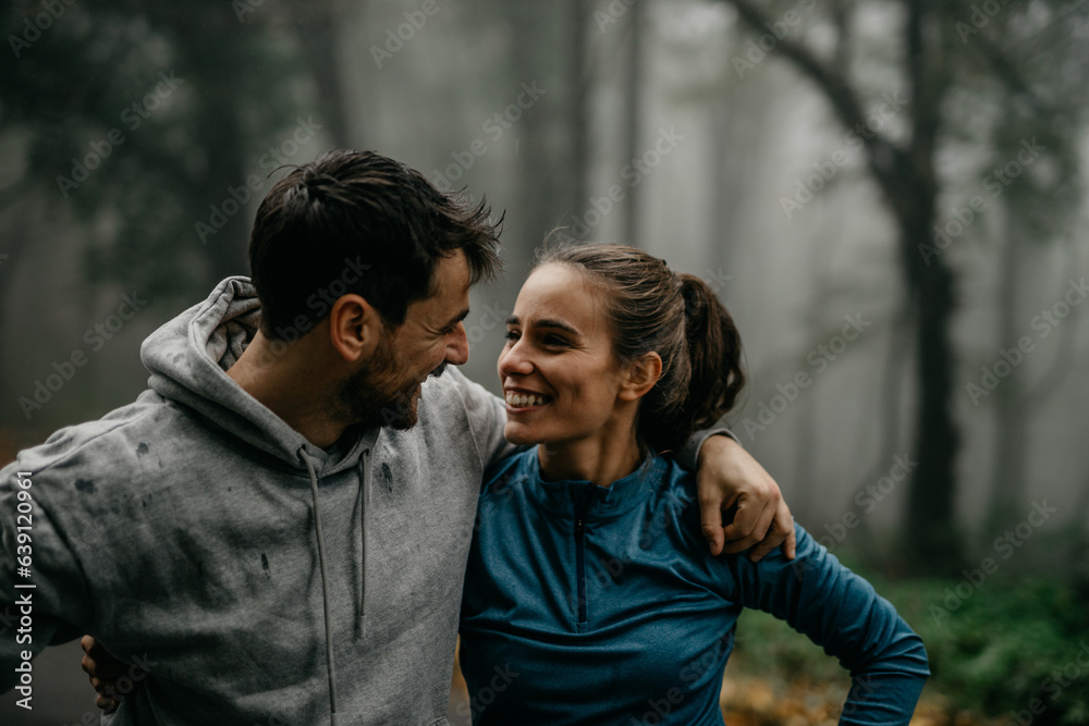 Two runners engaged in pre-run stretches amidst the misty atmosphere.