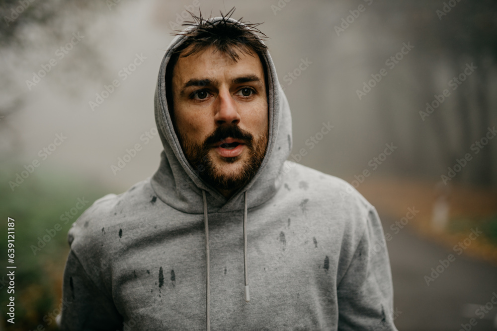 Close-up of a runner's determined expression as the pushes through the fog, determination clear in his eyes. Close-up of a runner's determined expression as the pushes through the fog, determination clear in his eyes.