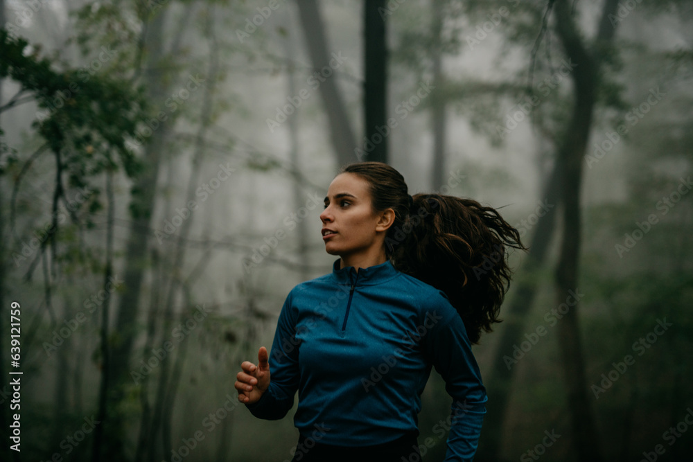A solo runner navigating a winding forest trail. A solo runner navigating a winding forest trail.