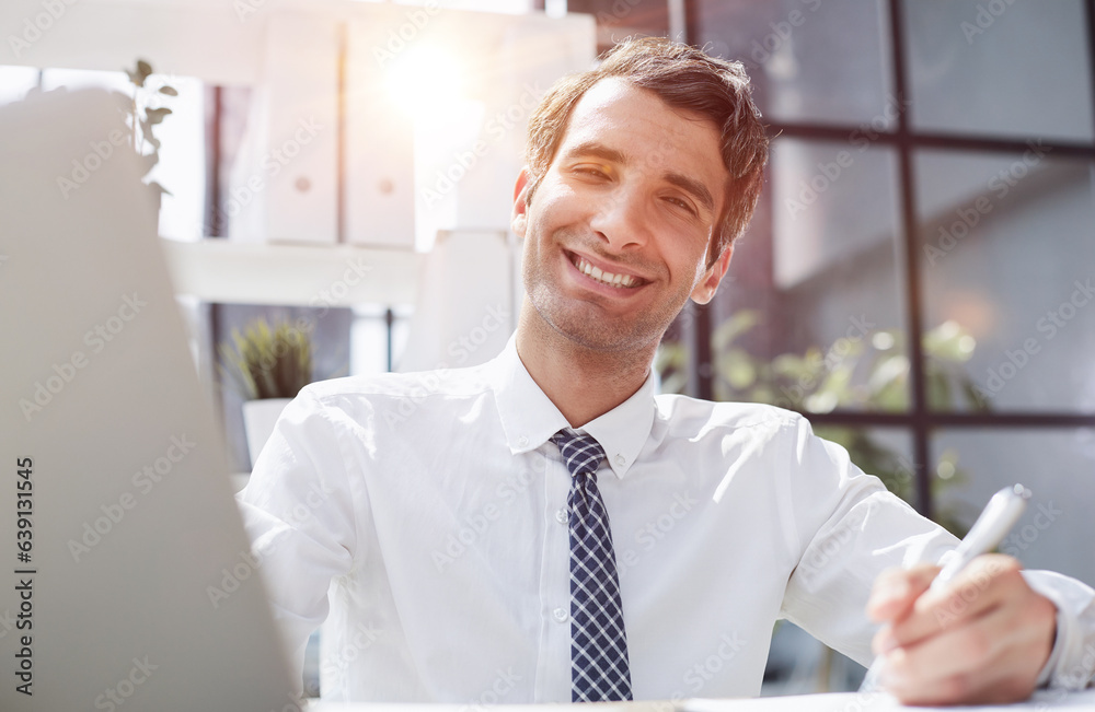 young businessman in a white shirt and tie working in a modern office. young businessman in a white shirt and tie working in a modern office.