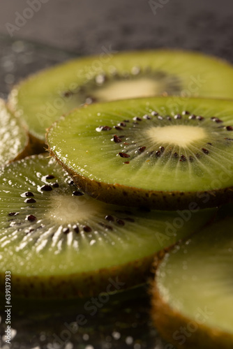 Micro close up of sliced kiwi fruit and copy space on black background