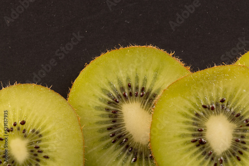 Micro close up of sliced kiwi fruit and copy space on black background
