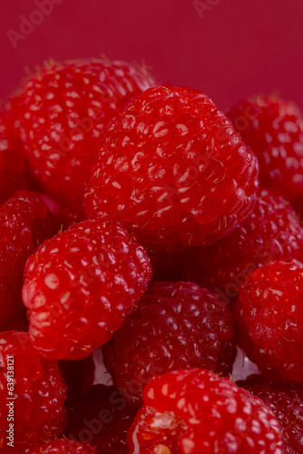 Micro close up of raspberries with copy space on red background