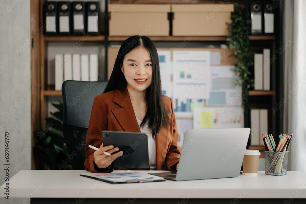 Business woman using tablet and laptop for doing math finance on an office desk, tax, report, accounting, statistics, and analytical research concept Business woman using tablet and laptop for doing math finance on an office desk, tax, report, accounting, statistics, and analytical research concept