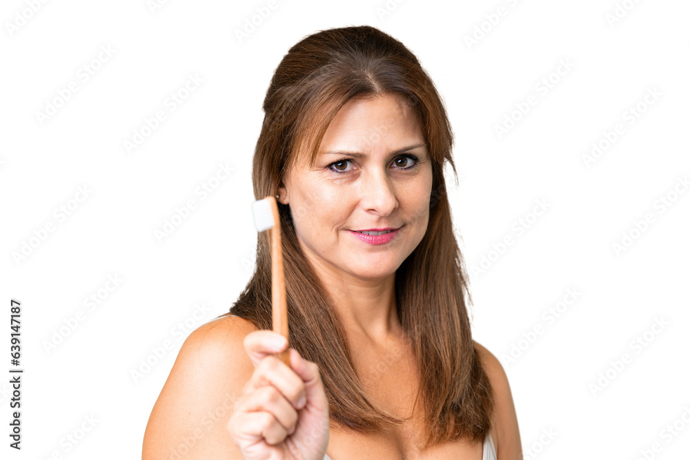Middle age woman over isolated background with a toothbrush Middle age woman over isolated background with a toothbrush