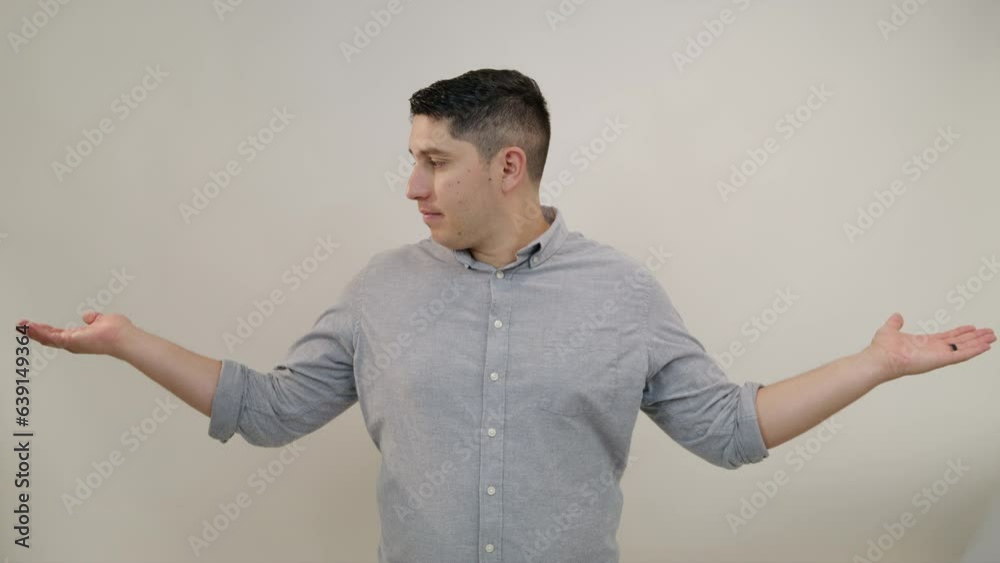Middle-aged attractive Hispanic man making scales gesture to make a choice. Positive man smiles, raises one hand higher, approvingly nodding his head. High quality 4k footage Middle-aged attractive Hispanic man making scales gesture to make a choice. Positive man smiles, raises one hand higher, approvingly nodding his head. High quality 4k footage